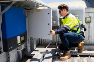 EnergyTec Technician wearing high-vis examines Meter board